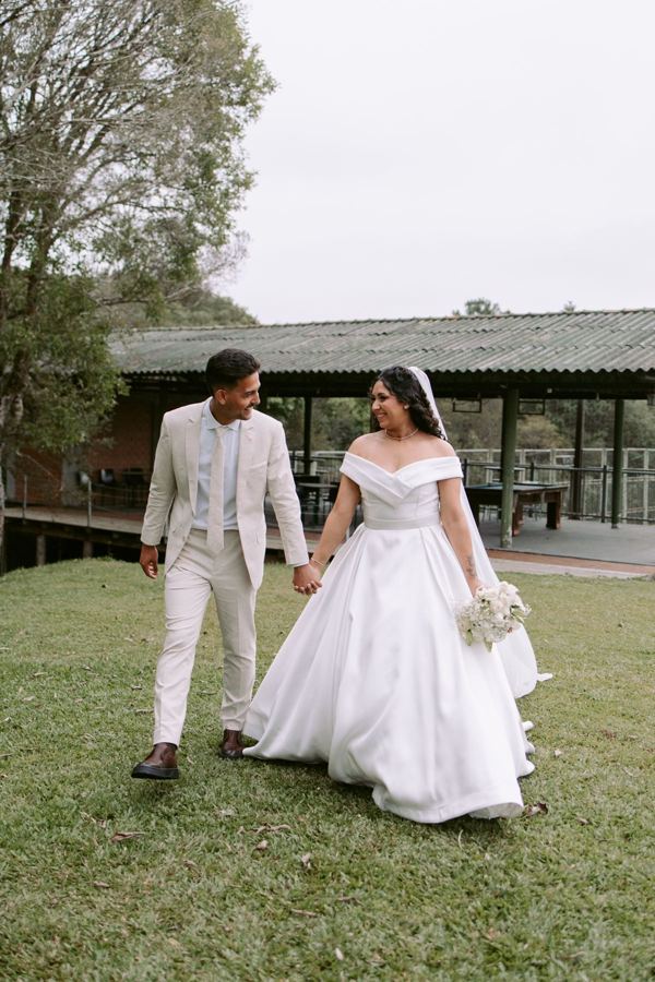 Casal de noivos caminhando de mãos dadas